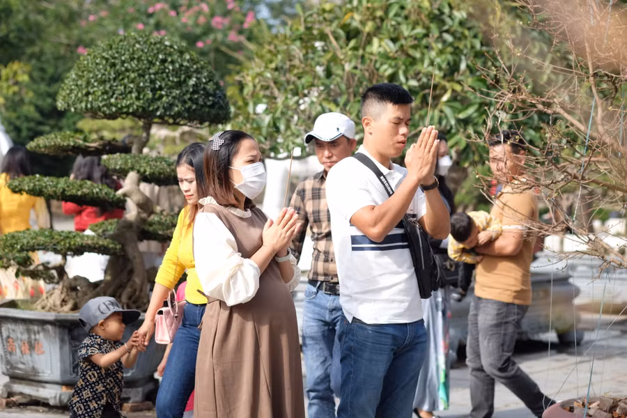 Một cặp vợ chồng đang cầu nguyện trước tượng Mẹ Quán Thế Âm Bồ Tát. Ảnh: Hoàng Vinh.