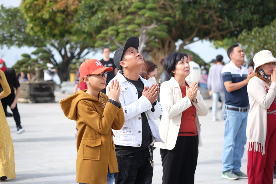 Không chỉ người lớn, trẻ em cũng chắp tay khấn nguyện để cầu bình an. Ảnh: Hoàng Vinh.