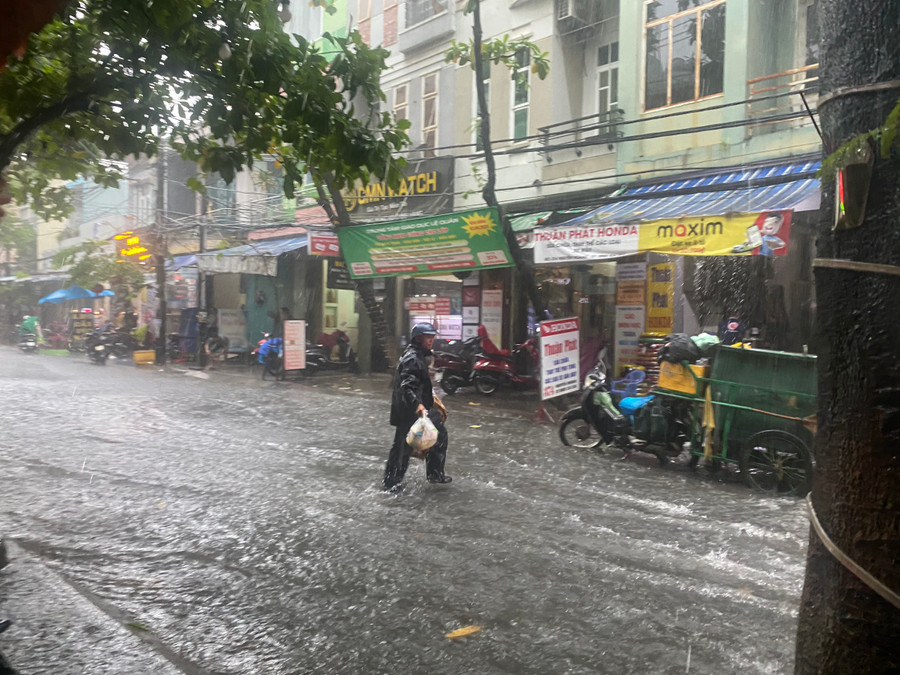 Công nhân vệ sinh môi trường đi nhặt rác tránh bị nước cuốn trôi xuống cống. (Ảnh: Hoàng Vinh). Công nhân vệ sinh môi trường đi nhặt rác tránh bị nước cuốn trôi xuống cống. (Ảnh: Hoàng Vinh).