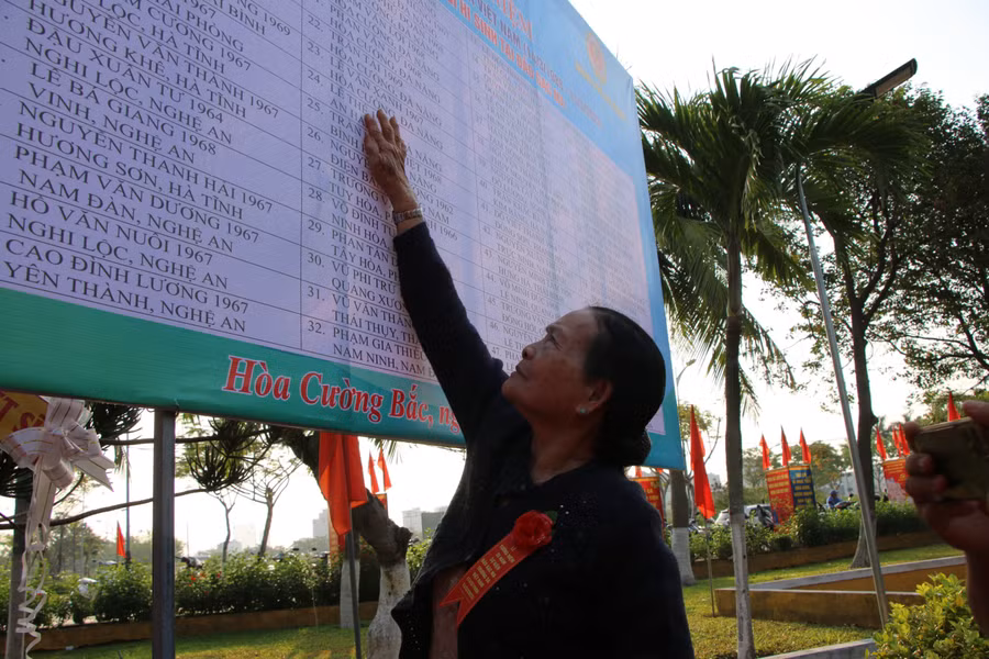 Bà Trần Thị Huệ đang tìm tên con trong bảng ghi danh 64 chiến sĩ hy sinh tại đảo Gạc Ma.