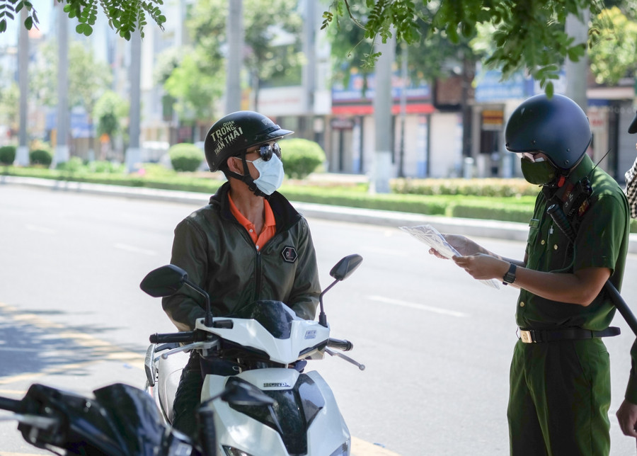 Lực lượng công an kiểm tra giấy đi đường của người dân. 