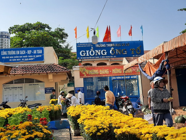 Cảnh nhộn nhịp mua bán hoa Tết trước cổng Trường THCS Giồng Ông Tố - Quận 2. Cảnh nhộn nhịp mua bán hoa Tết trước cổng Trường THCS Giồng Ông Tố - Quận 2.