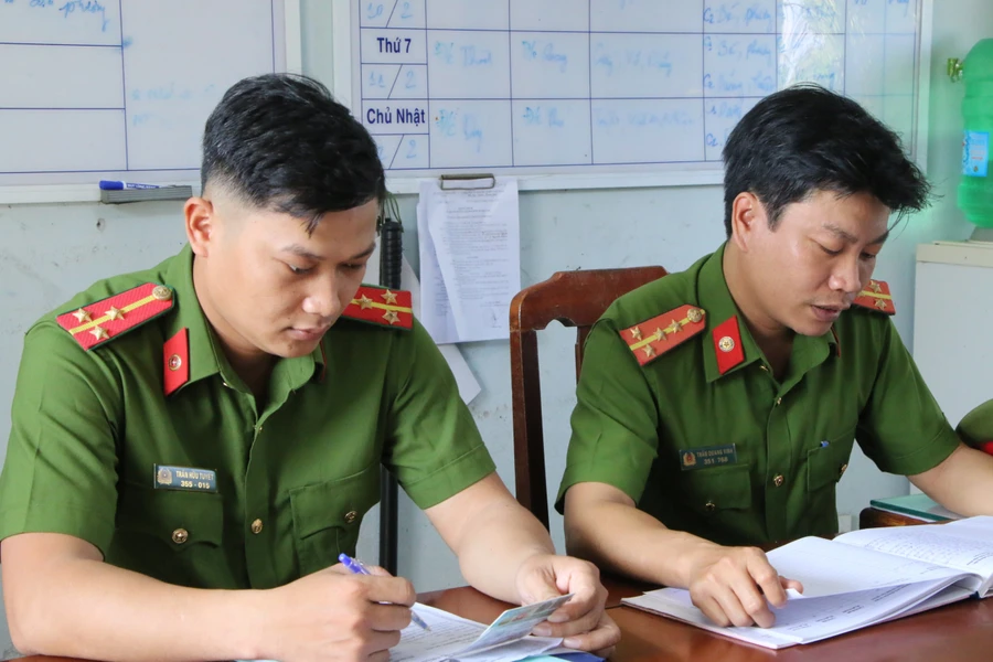 Đại uý Trần Quang Vinh, và Thượng uý Trần Hữu Tuyết – cán bộ Công an xã Hòa Tiến đang trực ban tại cơ quan. Ảnh: Hoàng Vinh. 