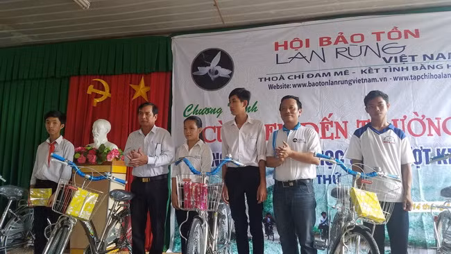 Đại diện lãnh đạo Hội Bảo tồn lan rừng Việt Nam và chính quyền địa phương trao tặng xe đạp và tập cho học sinh.