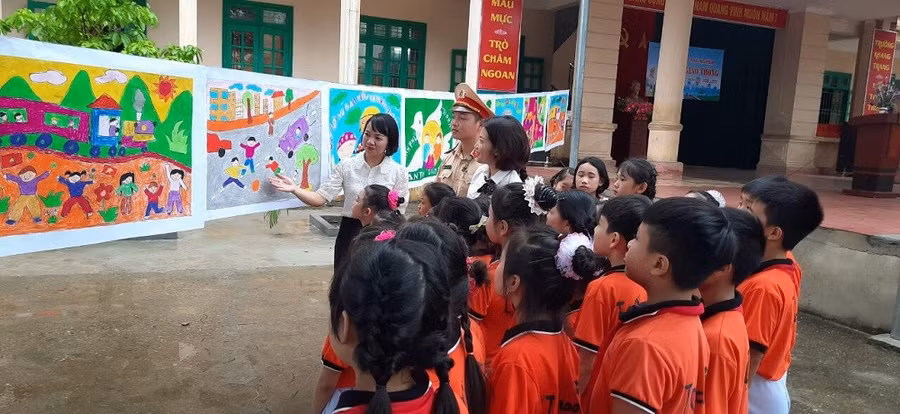 Cô giáo Hoàng Trà My - người sáng lập CLB Mỹ thuật nhà trường đang giới thiệu với khách tham quan tác phẩm của các em học sinh