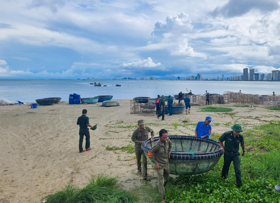 Bộ đội và chính quyền địa phương hỗ trợ ngư dân đưa thuyền thúng lên bờ tránh bão. Bộ đội và chính quyền địa phương hỗ trợ ngư dân đưa thuyền thúng lên bờ tránh bão.