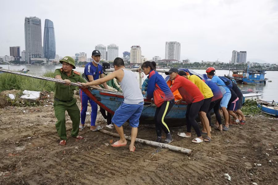 Công an cùng với người dân đưa thuyền lên bờ để tránh bão Noru.