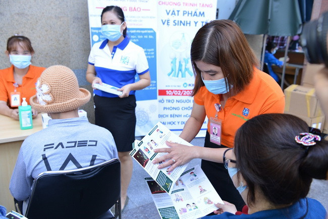 Nhân viên BV hướng dẫn tài liệu về phòng dịch nCoV cho người nhà bệnh nhân