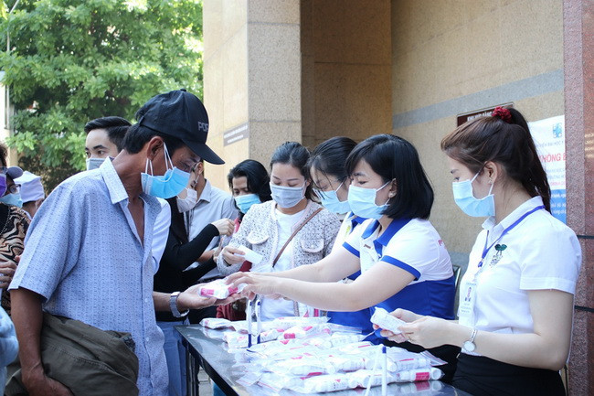 Phát dung dịch rửa tay cho người nhà bệnh nhân đến khám tại bệnh viện