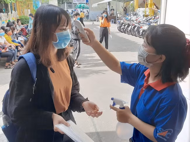 Thí sinh được đo thân nhiệt và rửa tay kháng khuẩn để vào trường thi