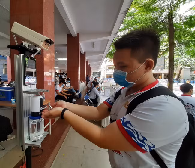 Sinh viên Trường CĐ Kỹ thuật Cao Thắng đo thân nhiệt và rửa tay kháng khuẩn.