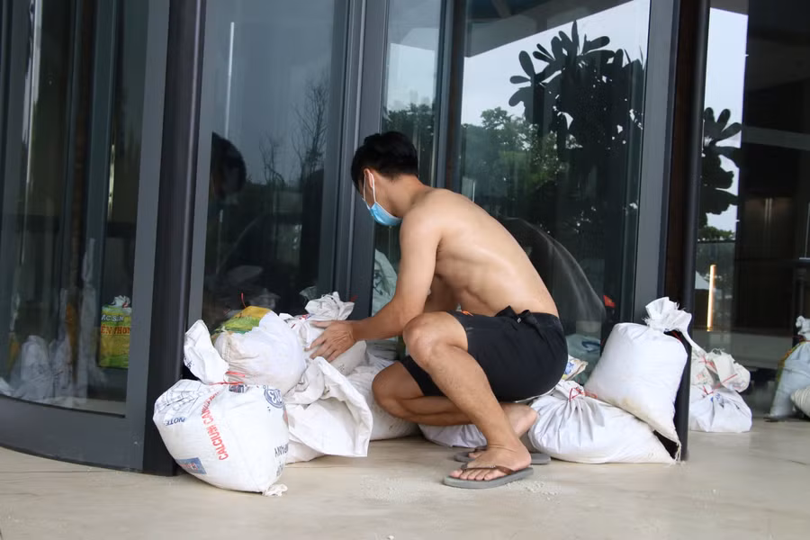 Ở các khách sạn ven biển, nhân viên đang canh trực “3 tại chỗ” tận dụng bao cát và nhiều thanh gỗ để chèn cửa nẻo vào sảnh chính khách sạn. Không khí phòng chống bão số 5 đang rất tất bật tại Đà Nẵng.