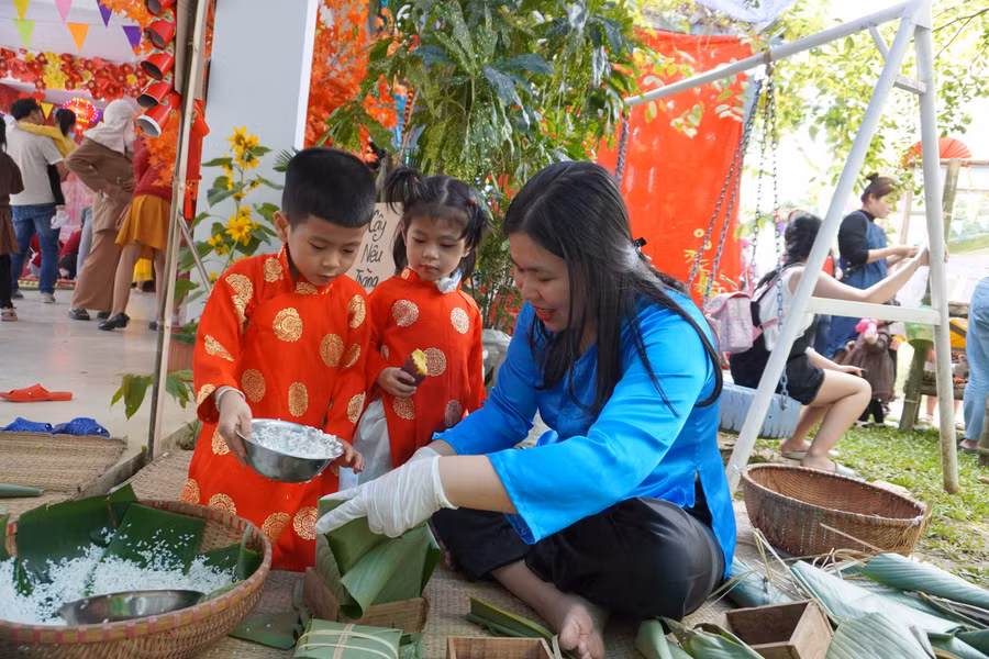 Trẻ mầm non được trải nghiệm gói bánh chưng.