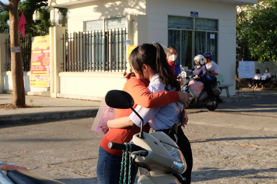 Chị Võ Thị Kim Yến ôm động viên con trước khi con vào phòng thi. Ảnh: Hoàng Vinh.