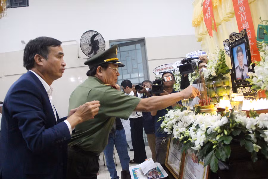 Đại diện lãnh đạo UBND TP và lãnh đạo Công an TP Đà Nẵng thắp hương cho ông Trần Minh Thành. (Ảnh: Hoàng Vinh).