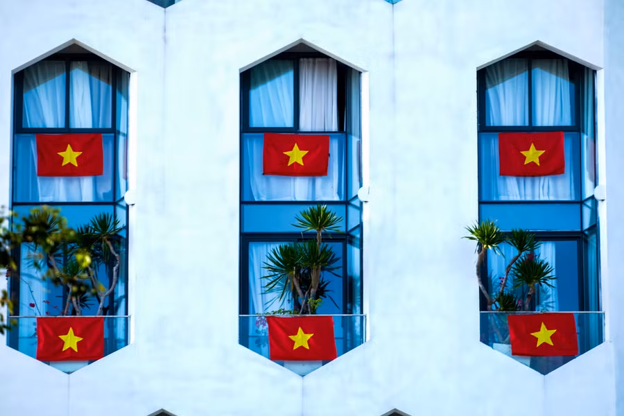 Lá cờ tổ quốc được treo xung quanh các khung cửa ở tòa nhà cao tầng.