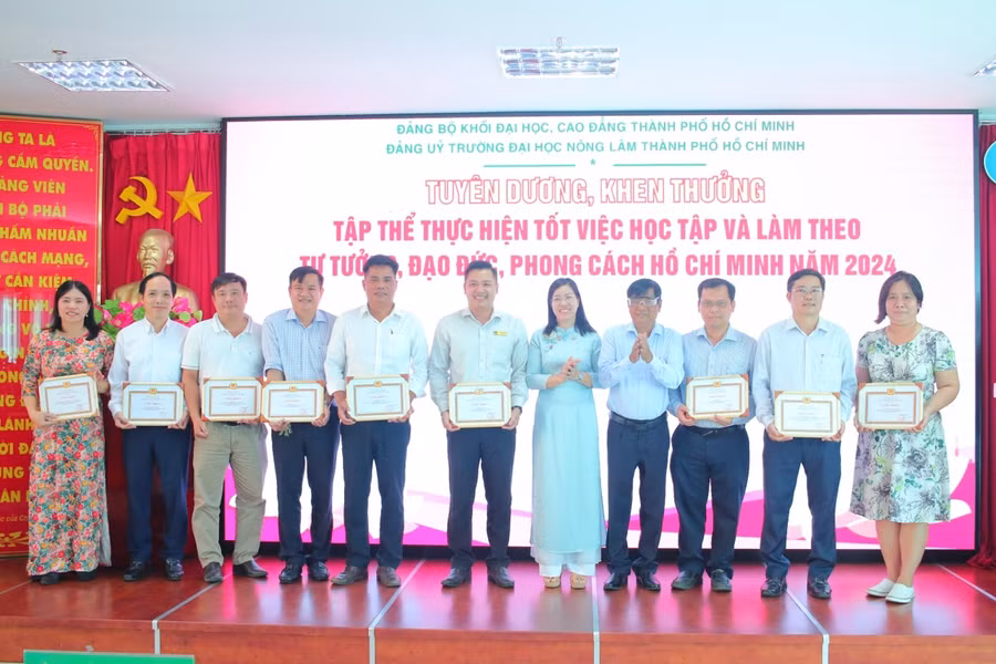 Bà Nguyễn Thị Là, Phó Bí thư thường trực Đảng ủy Khối và ông Bùi Ngọc Hùng, Bí thư Đảng ủy, Chủ tịch Hội Đồng trường trao giấy khen cho các tập thể thực hiện tốt việc học tập và làm theo tư tưởng, đạo đức, phong cách Hồ Chí Minh năm 2024. (Ảnh: Khánh Huy)