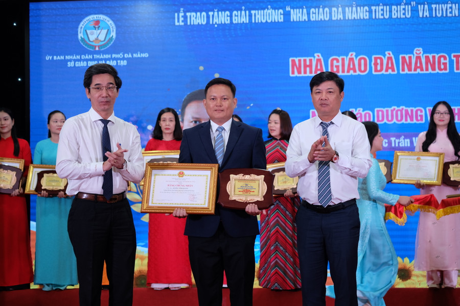 Ông Lương Nguyễn Minh Triết (áo trắng bên phải) - Phó Bí thư Thường trực Thành ủy, Chủ tịch HĐND TP Đà Nẵng và ông Trần Chí Cường (áo trắng bên trái) - Phó Chủ tịch UBND TP Đà Nẵng trao giải thưởng Nhà giáo Đà Nẵng tiêu biểu cho các giáo viên. (Ảnh: Hoàng Vinh)