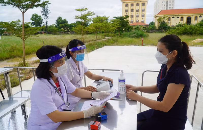 Các đối tượng tiêm chủng được cán bộ y tế khám sàng lọc và tư vấn kỹ càng trước khi ký giấy đồng ý tham gia tiêm vắc xin phòng Covid-19 (Ảnh: Nguyễn Hoàng).