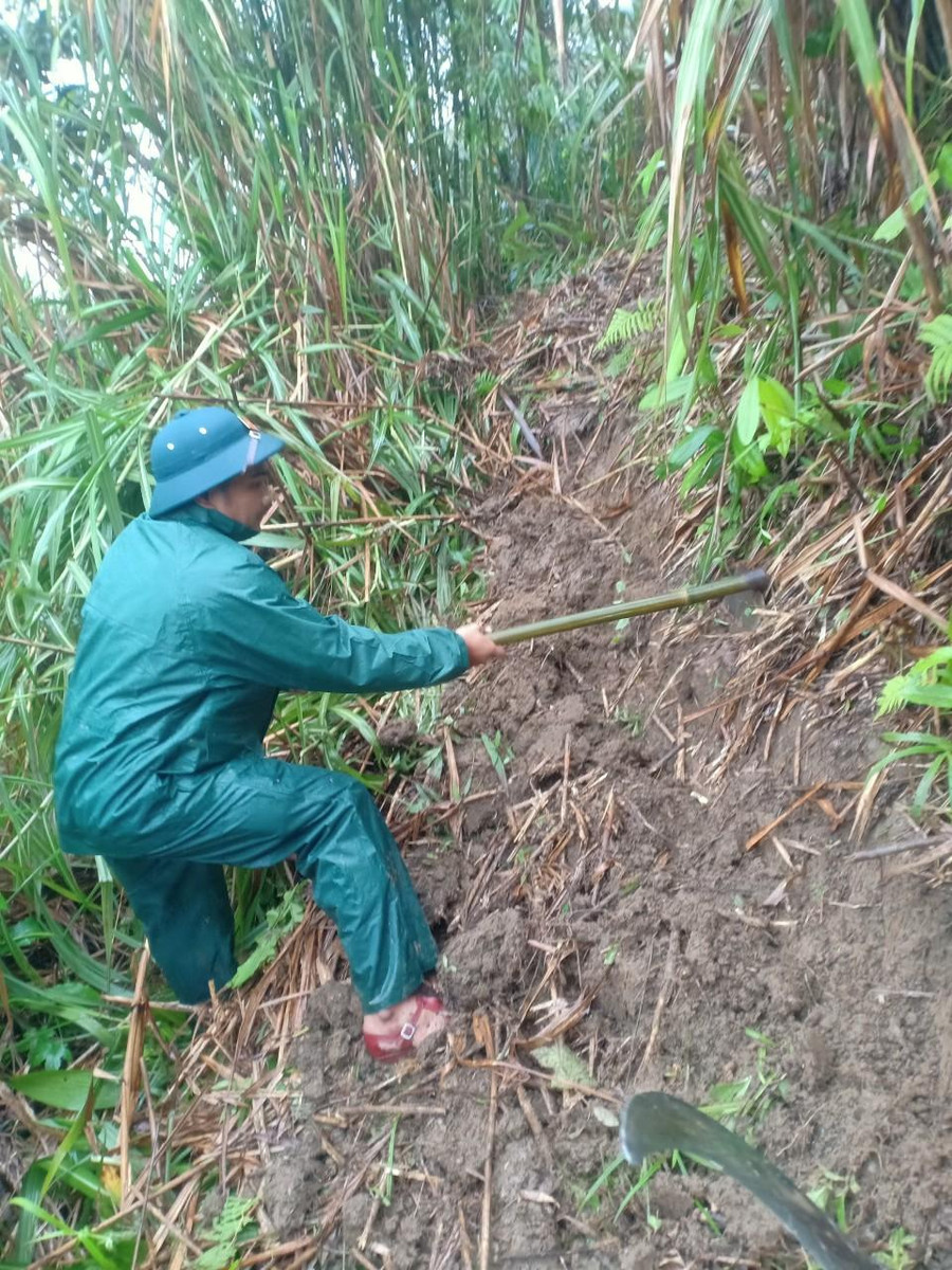 Lực lượng dân quân tự vệ, bộ đội và công an mở đường tạm cho người dân đi lại.