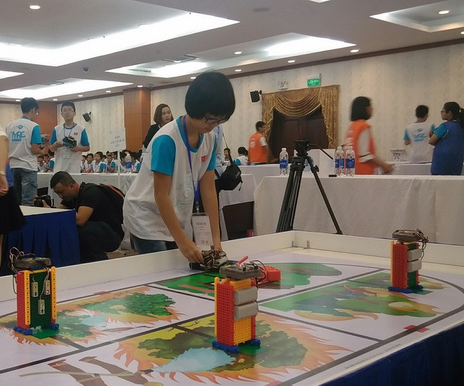 Thí sinh Lê Linh Nghi, Trường Tiểu học Trần Quốc Tuấn, quận Tân Bình, TPHCM đang điều trỉnh robot của mình để sẵn sằng thi đấu tại bảng đấu Giải cứu rừng