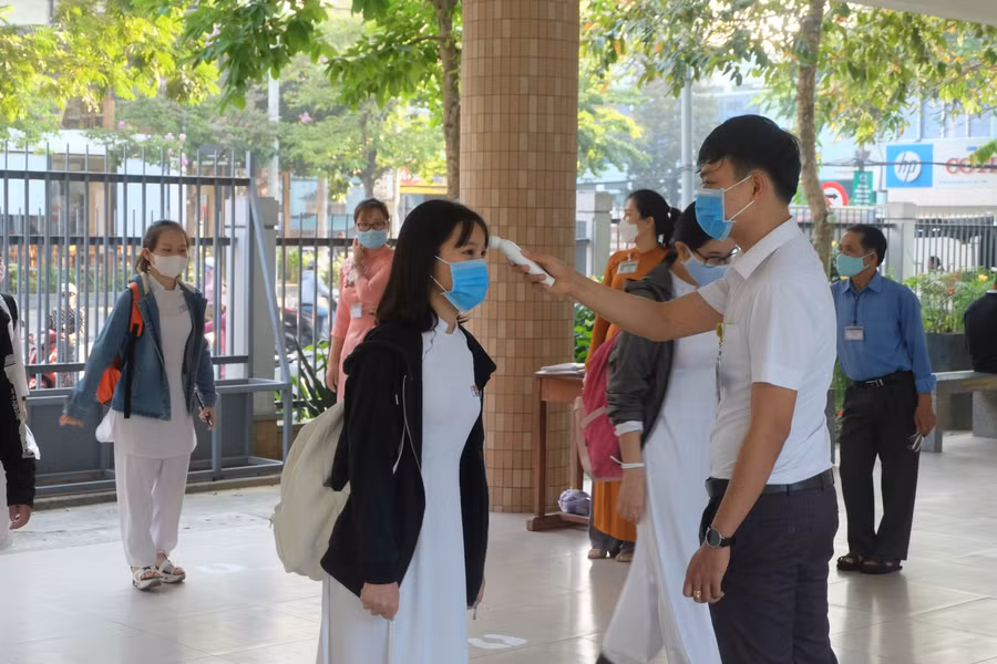 Đo thân nhiệt cho học sinh trước khi vào lớp. Ảnh tư liệu