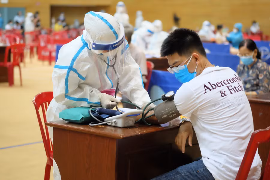 Đo huyết áp và khám sàn lọc trước khi tiêm vắc xin. 