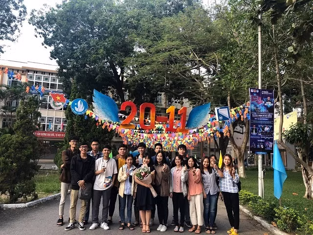 Thạc sĩ Lê Tường Vi (cầm hoa) chụp ảnh cùng các bạn sinh viên.