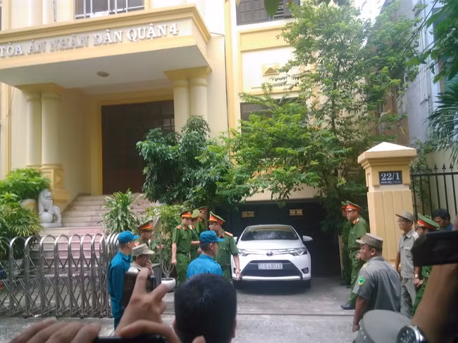 Chiếc xe màu trắng đưa bị cáo Nguyễn Hữu Linh rời khỏi tòa tránh ống kính của phóng viên