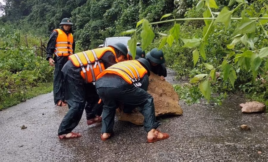 Lực lượng chức năng xử lí những tảng đá rơi xuống đường để đảm bảo lưu thông.