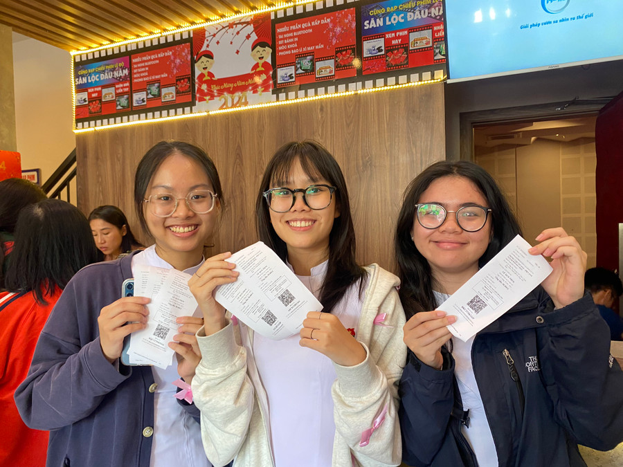 Quỳnh Nhi (ở giữa) cùng 2 người bạn tươi cười sau khi mua được 6 tấm vé xem phim. Quỳnh Nhi (ở giữa) cùng 2 người bạn tươi cười sau khi mua được 6 tấm vé xem phim.