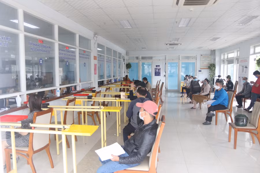 Người dân ngồi đợi làm thủ tục đổi biển số xe.