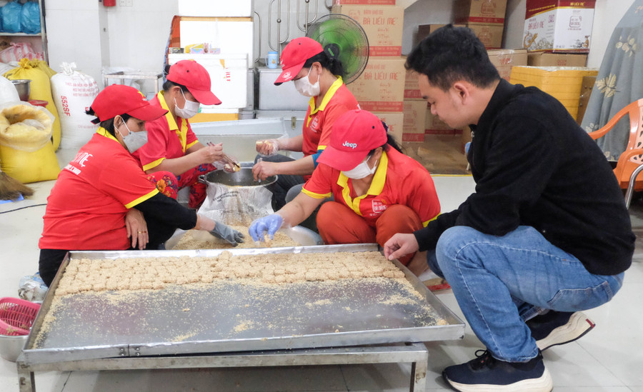 Anh Huỳnh Đức Sol (mặc áo đen) - chủ cơ sở sản xuất bánh khô mè Bà Liễu Mẹ kiểm tra sản phẩm.