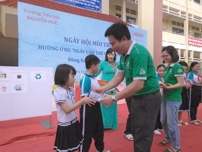 Đại diện Công ty Nestlé Việt Nam trao nhiều phần quà cho các đội chơi thắng cuộc trong các phần thi vẽ tranh, tìm hiểu phân loại xử lý rác thải và bảo vệ môi trường.