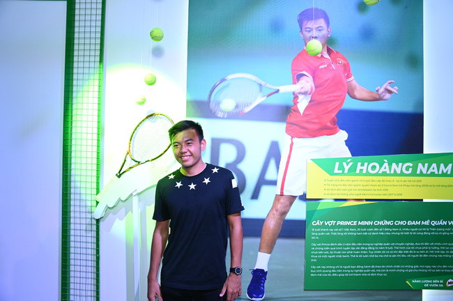Vận động viên quần vợt nổi tiếng Lý Hoàng Nam bên cây vợt bị bung lưới trưng bày tại triển lãm. Vận động viên quần vợt nổi tiếng Lý Hoàng Nam bên cây vợt bị bung lưới trưng bày tại triển lãm.