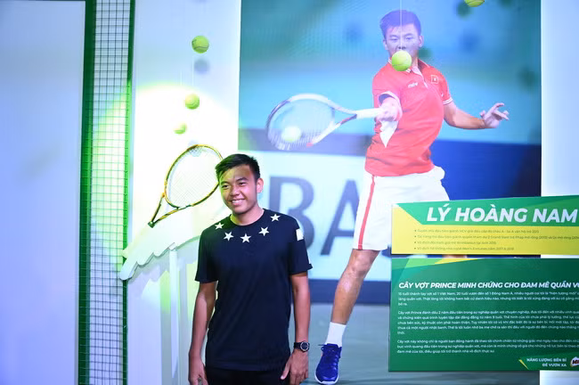 Vận động viên quần vợt nổi tiếng Lý Hoàng Nam bên cây vợt bị bung lưới trưng bày tại triển lãm.