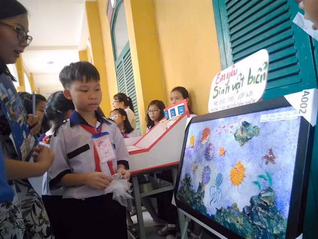 Thí sinh Võ Trí Đức - lớp 5 trường TH Nguyễn Bỉnh Khiêm với bức tranh " Em yêu sinh vật biển" . Ý tưởng làm từ chất liệu tái chế như ống hút, khay đựng trứng, giấy xốp... ra những con tôm, con cá rất đẹp mắt và thân thiện với môi trường.