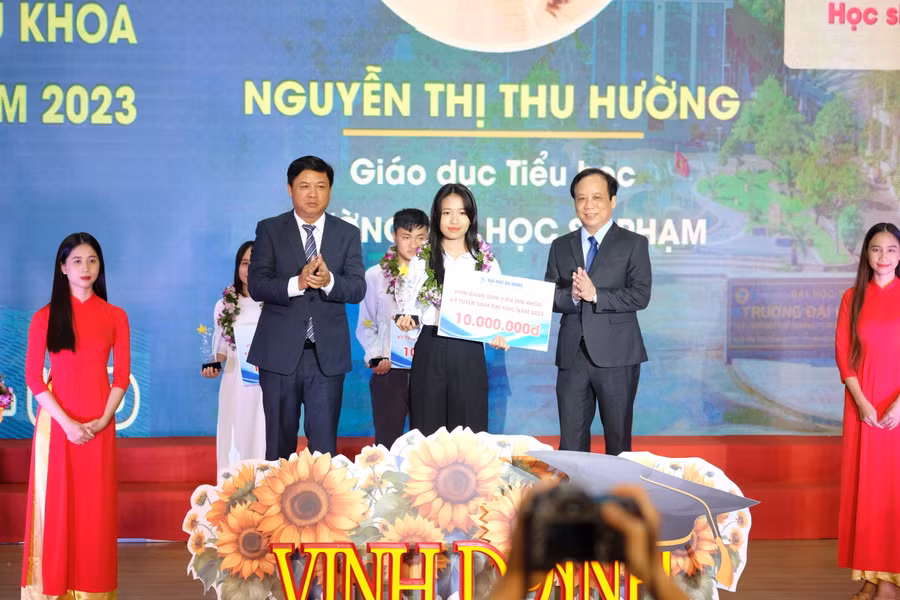 Ông Lương Nguyễn Minh Triết (thứ 2, trái sang) - Phó Bí thư Thường trực Thành ủy, Chủ tịch HĐND TP Đà Nẵng và PGS.TS Nguyễn Ngọc Vũ - Giám đốc Đại học Đà Nẵng tặng biểu trưng vinh danh và số tiền thưởng 10 triệu đồng cho các Thủ khoa. 