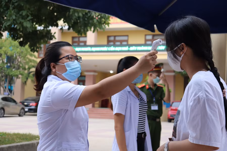 Tiếp tục công tác kiểm tra thân nhiệt đối với các thí sinh trước khi vào phòng thi.