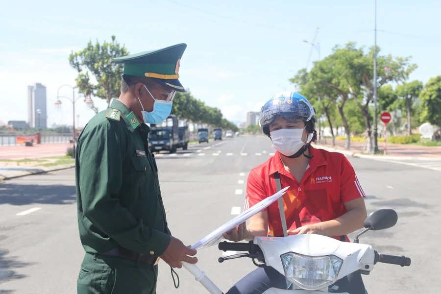 Lực lượng chức năng đang kiểm tra thông tin giấy đi đường của người dân. Ảnh minh họa. 