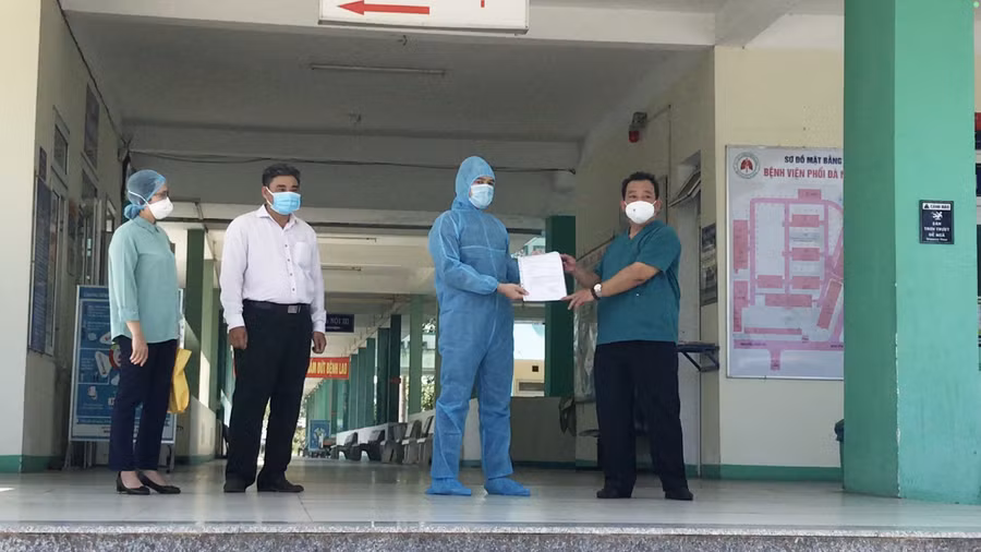 Bác sĩ Lê Thành Phúc (ngoài cùng, bìa phải) - Giám đốc Bệnh viện Phổi Đà Nẵng trao giấy ra viện cho bệnh nhân. 