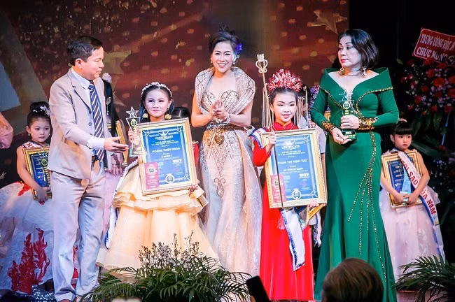 Các vị giám khảo trao giải Á quân cho thi sinh Hoàng Thiên Ngân và Phạm Thị Minh Thư .