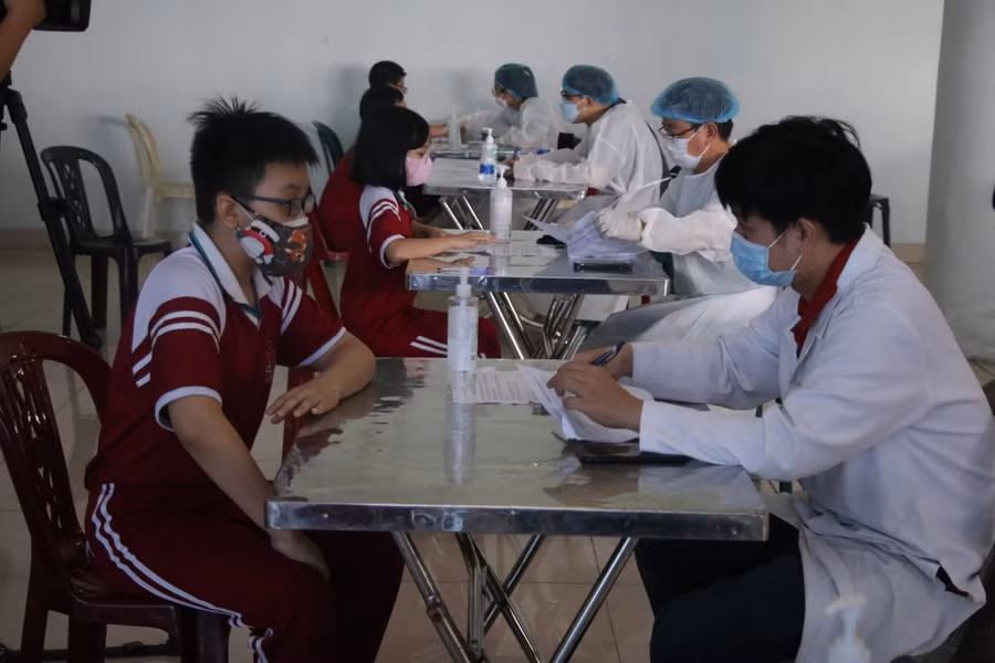 Các bác sĩ kiểm tra thông tin, khám và tư vấn cho học sinh trước khi tiêm.