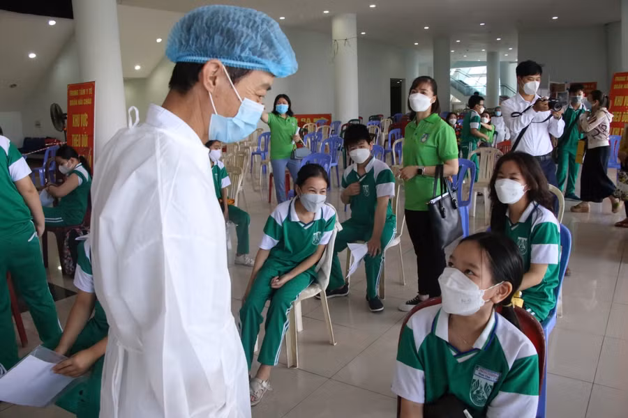 Bác sĩ hỏi thăm sức khỏe của các em sau khi tiêm.