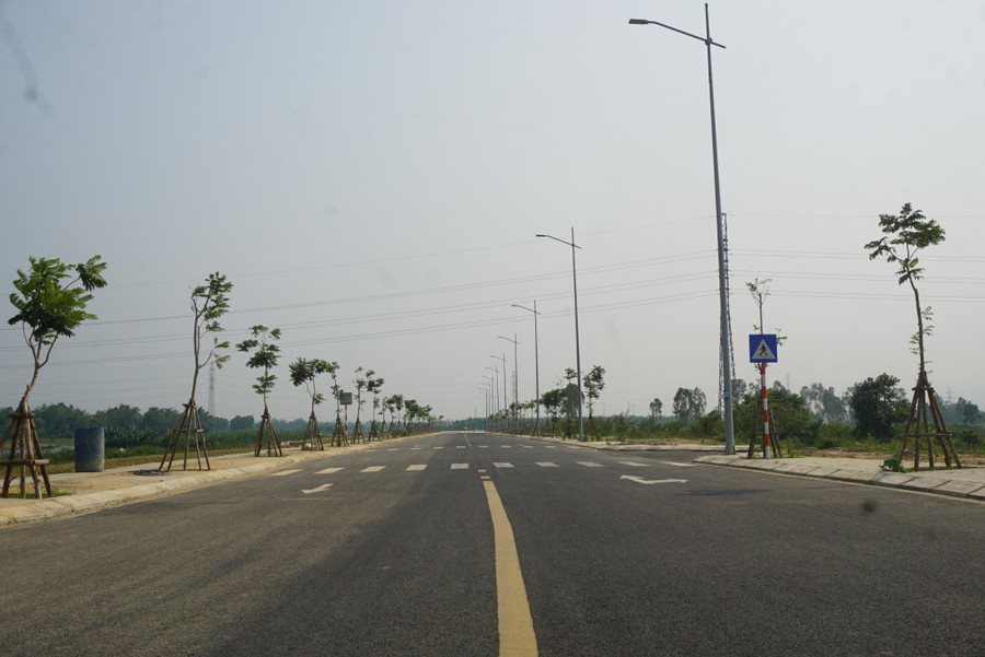 Dự án khi hoàn thành sẽ giúp người dân huyện Hòa Vang rút ngắn thời gian và thuận tiện hơn khi di chuyển vào các quận trung tâm TP Đà Nẵng. Hiện công nhân đang làm sạch mặt đường. Ảnh: Hoàng Vinh.