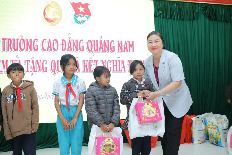 PGS.TS Vũ Thị Phương Anh - Hiệu trưởng Trường Cao đẳng Quảng Nam trao quà cho các em học sinh có hoàn cảnh khó khăn. 