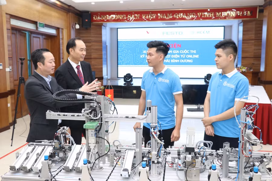 Hiệu trưởng Đồng Văn Ngọc và PGS. TS Dương Đức Lân - Chủ tịch Hiệp hội giáo dục nghề nghiệp và công tác xã hội Việt Nam trao đổi kỹ thuật với hai thí sinh tham dự cuộc thi