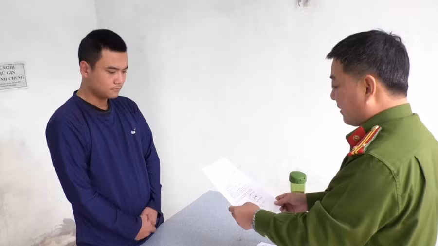 Công an tống đạt quyết định với Trương Việt Hoàng. (Ảnh: Công an)