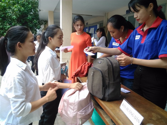 Thí sinh được các tình nguyện viên hướng dẫn và cất giữ đồ tư trang trước khi vào phòng thi.