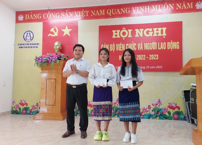 Được sự ủy quyền, thầy Phạm Hồng Việt, Hiệu trưởng Trường phổ thông Dân tộc nội trú tỉnh tặng quà của Bí thư Tỉnh ủy Quảng Bình cho em Cao Thị Lệ Hằng và em Vũ Thị Lích.